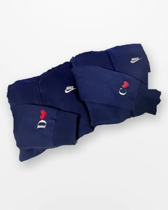 Matching hoodies with embroidered initials and red hearts on the cuffs